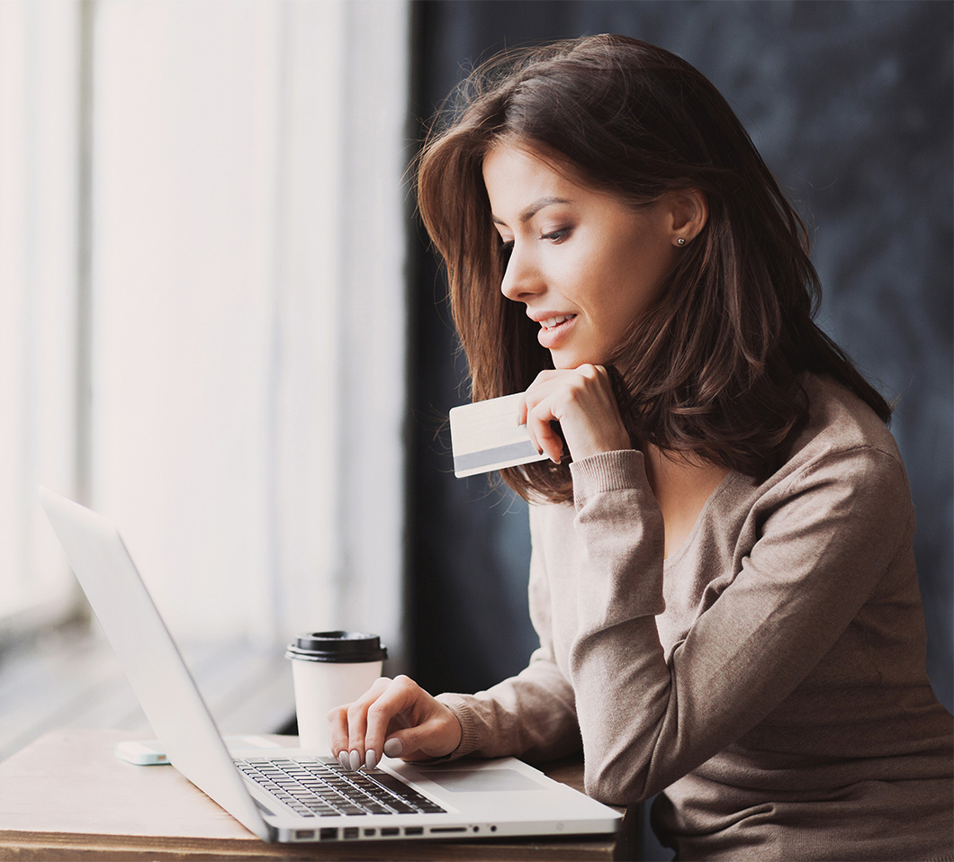 woman on laptop holding credit card