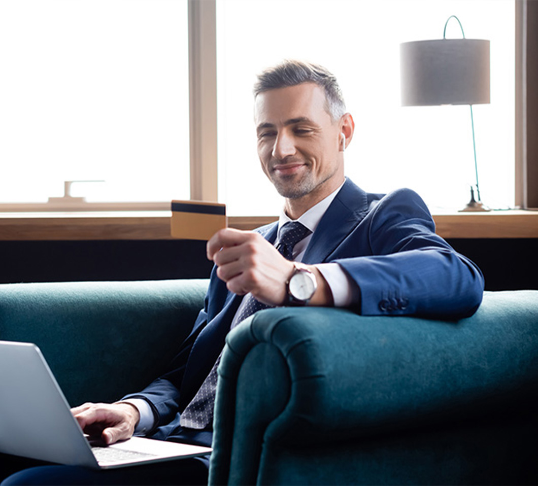 young man with credit card on laptop