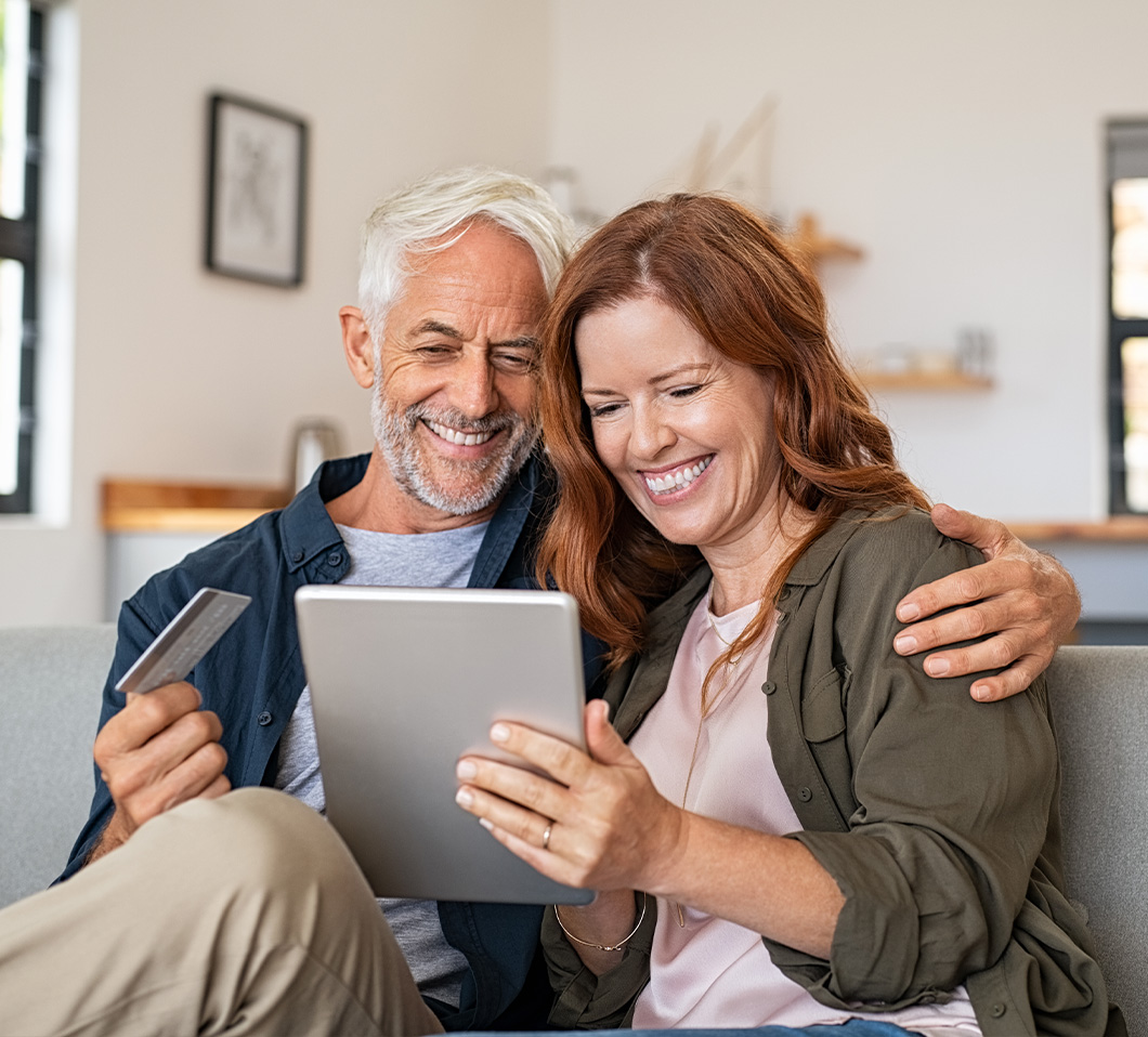 couple smiling looking at tablet