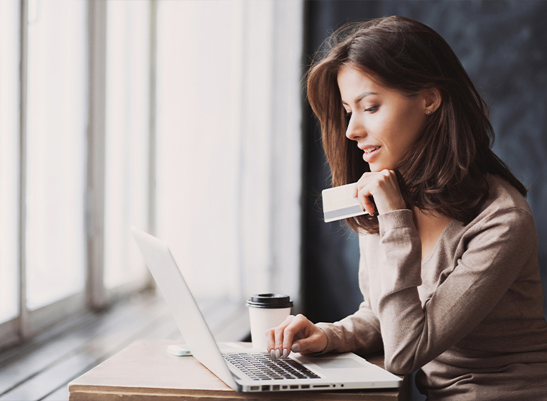 woman on laptop holding credit card