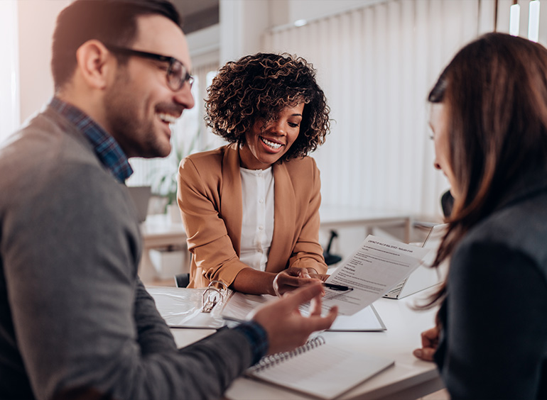 three people around desk receiving consultation