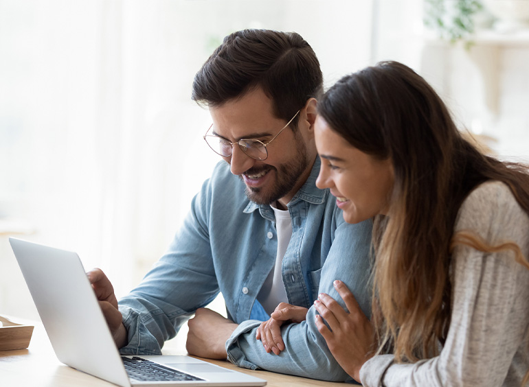 couple on laptop smiling