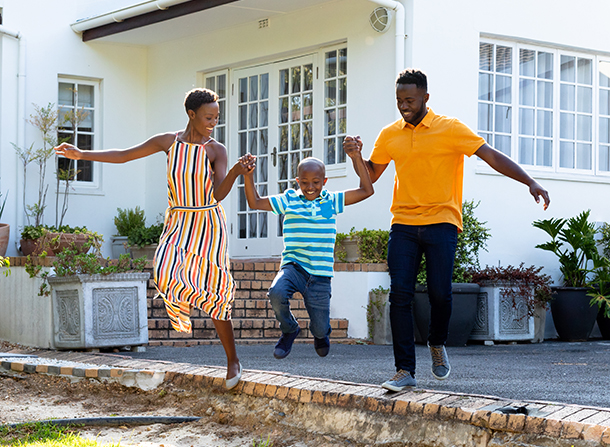 2 adults and a child jumping